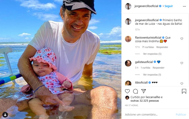 Jorge Vercillo posa com a filha caçula em seu primeiro banho de mar