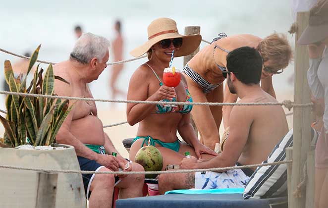 Sula Miranda tomando drink na praia com amigos