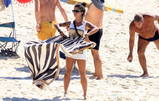 Aline Riscado arrumando manta para sentar na areia da Praia de Ipanema