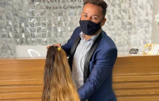 Luiz Crispim segurando um dos seus modelos de cabelos