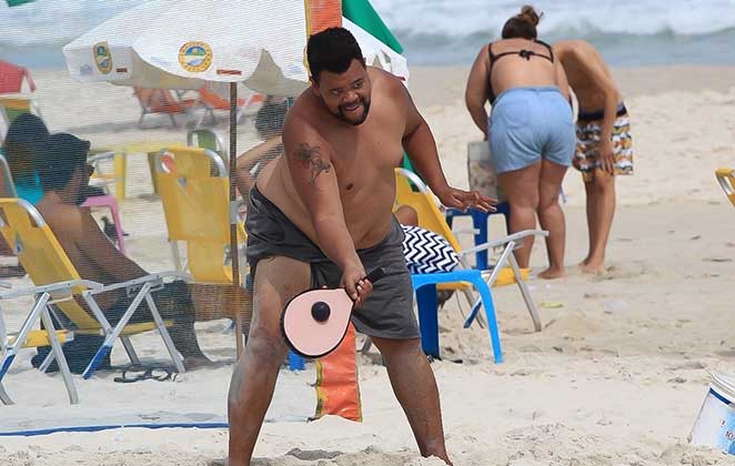 Babu acerta a raquete na bolinha de frescobol, em dia de praia, no Rio de Janeiro