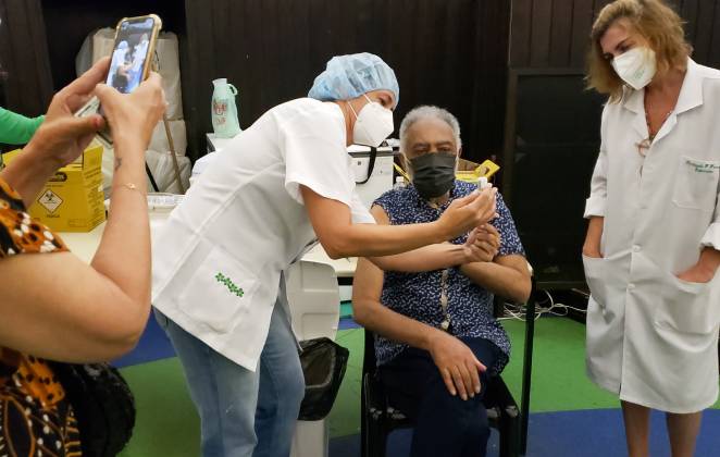 Fãs fotografando Gilberto Gil sendo imunizado contra covid-19