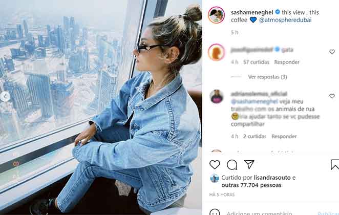 Sasha admira a paisagem em janela de restaurante chique em Dubai