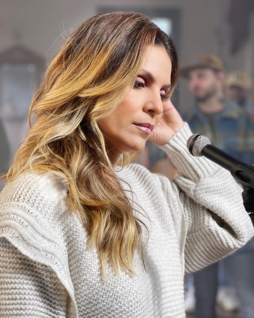 Aline Barros de perfil, blusa branca, cabelos soltos