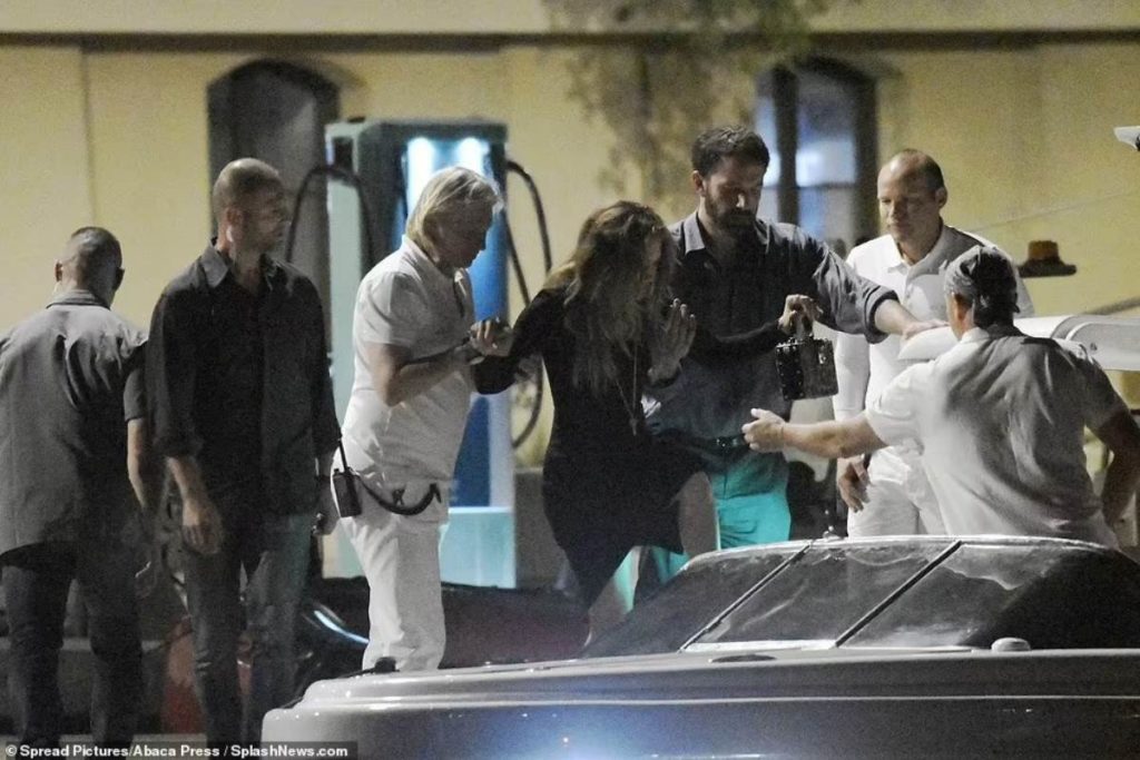 Tripulantes ajudam Jennifer Lopez embarcar em um pequeno barco para retornar ao iate após jantar em Saint-Tropez.