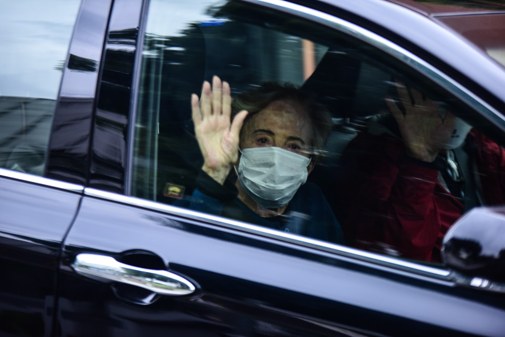 Glória Menezes acenando para os fotógrafos na saída do hospital