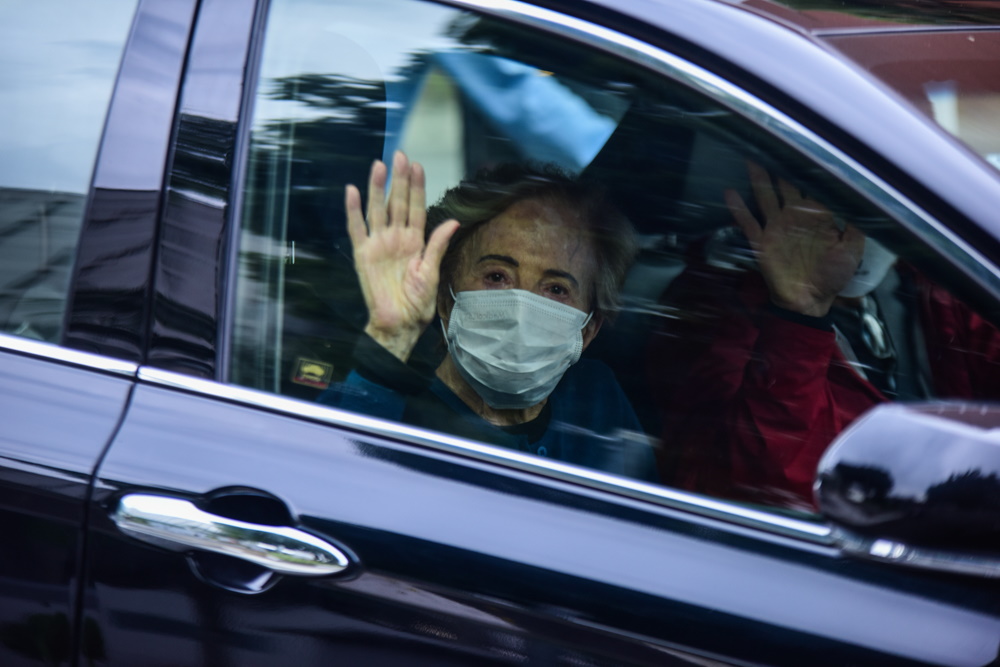 Glória Menezes acenando para os fotógrafos na saída do hospital