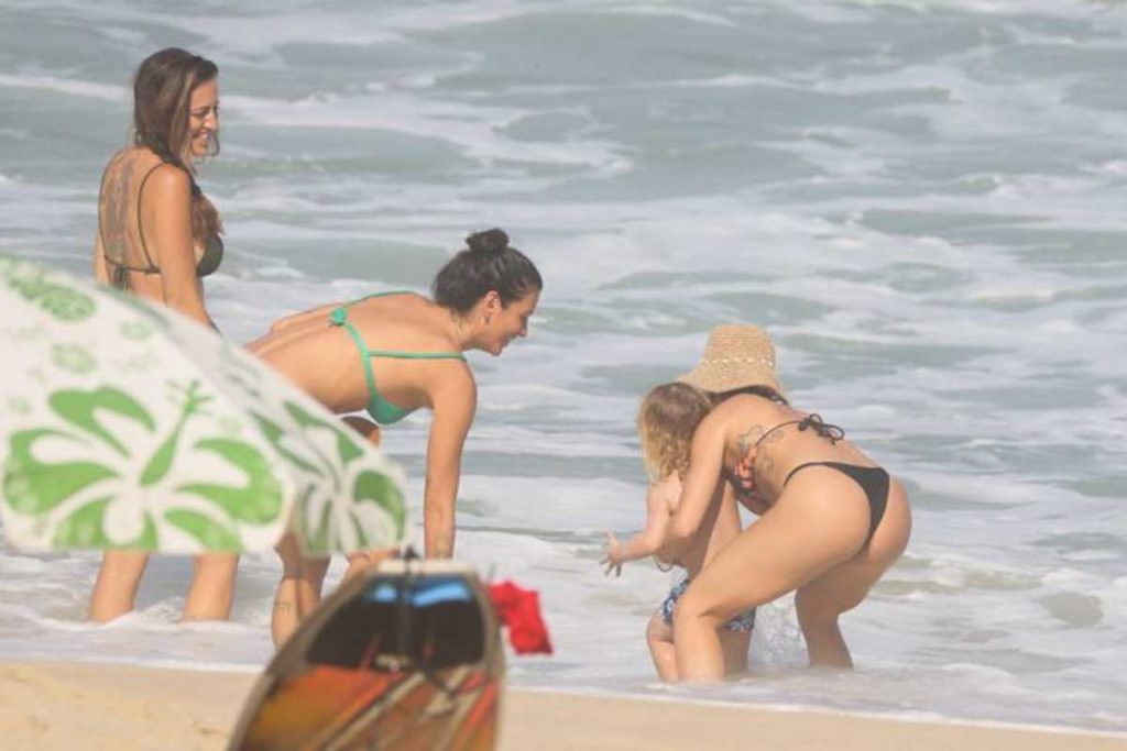 Isis Valverde brincando com o filho ao lado das amigas na praia
