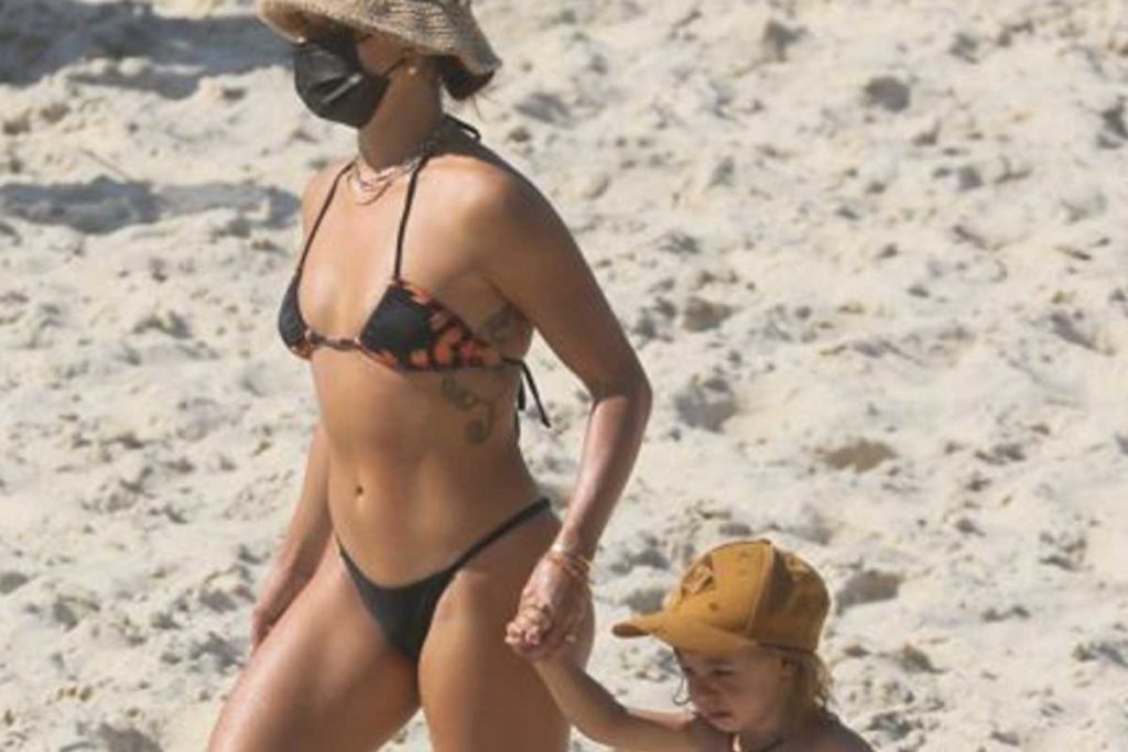 isis valverde na praia com biquíni invertido segurando a mão do filho rael