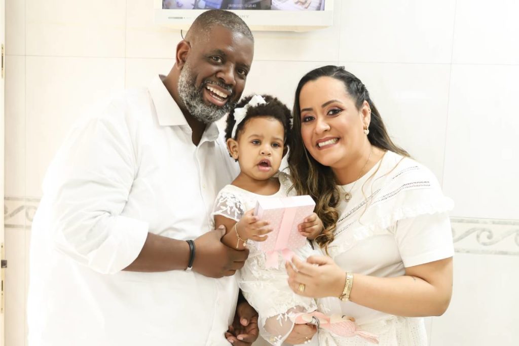 péricles, lidiane e maria helena de branco abraçadas em batismo