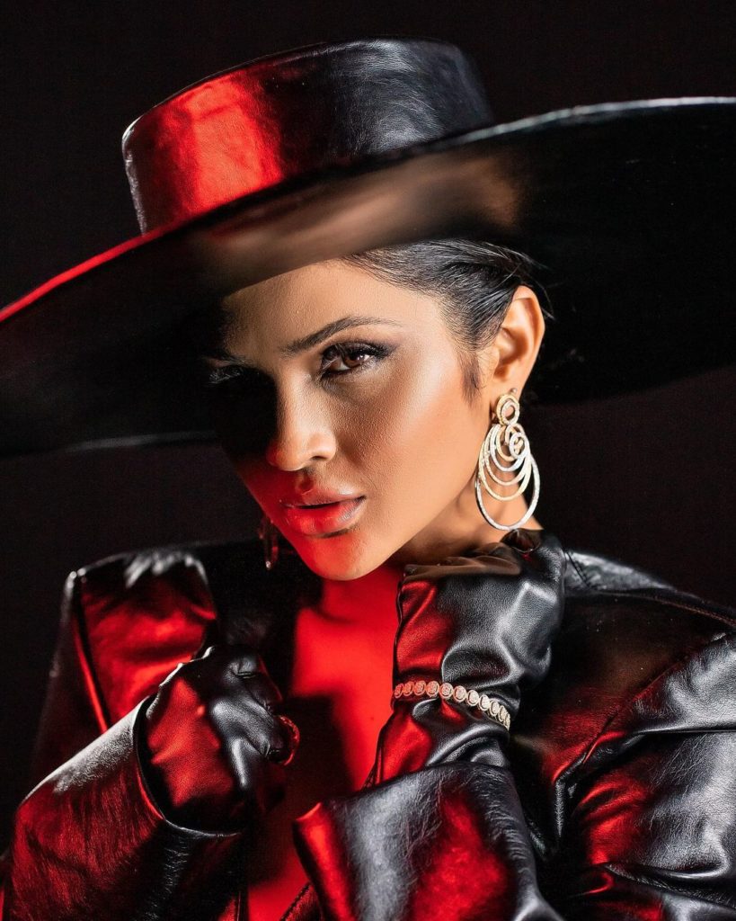 Mileide Mihaile com chapéu de couro preto e luvas vermelhas