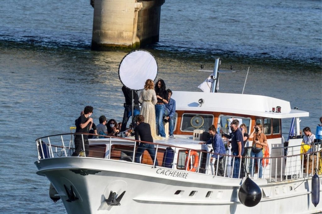 Cercada por uma equipe de produção enorme, Julia Roberts desce o rio Sena, em Paris.