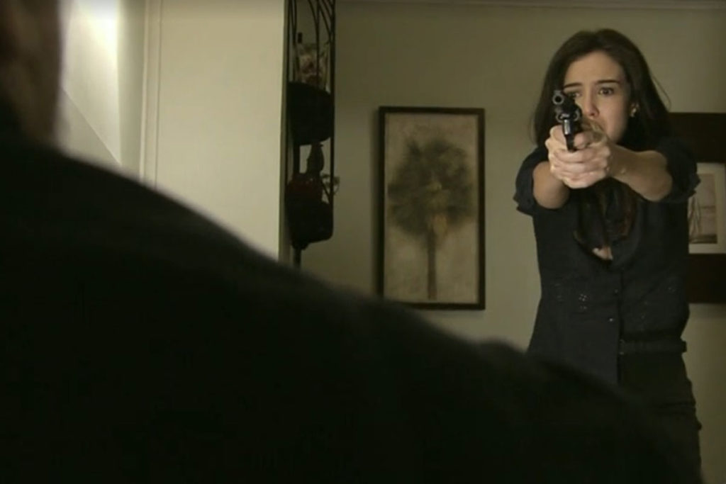 Cora aponta uma arma para Reginaldo