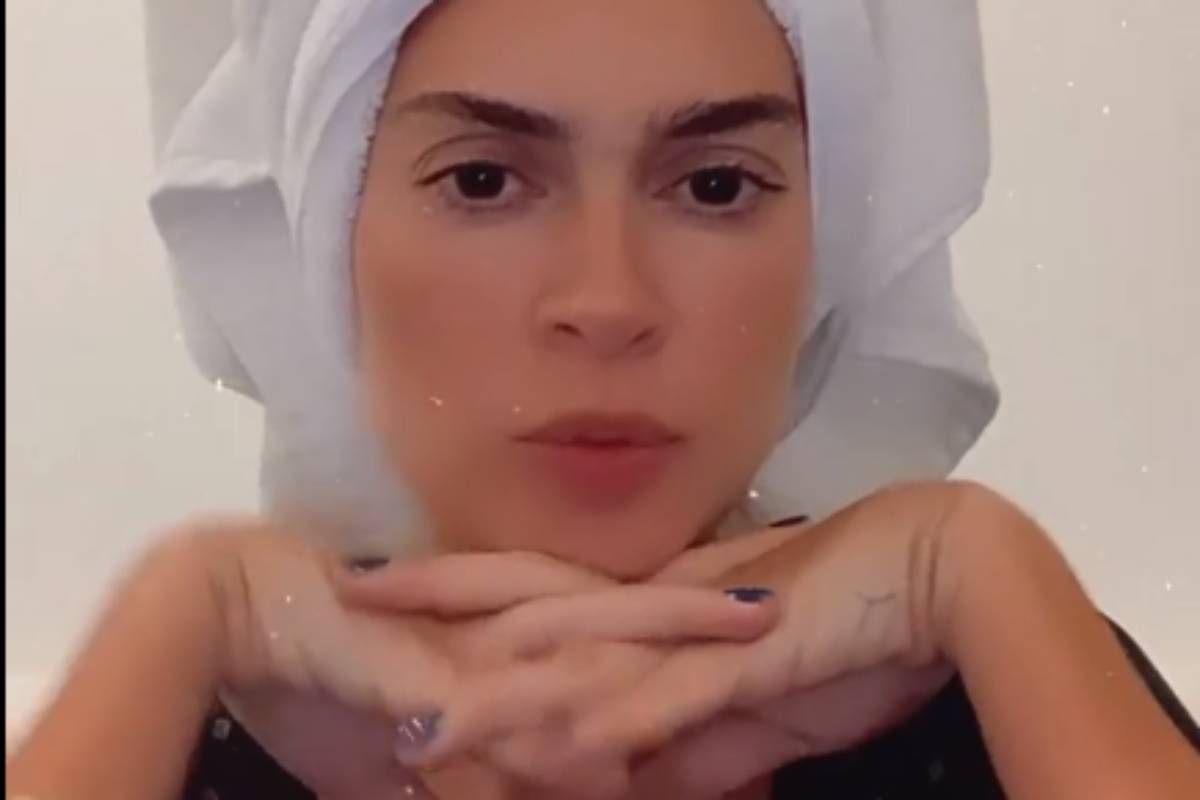 thaila ayala em vídeo com toalha na cabeça séria e mãos embaixo do queixo