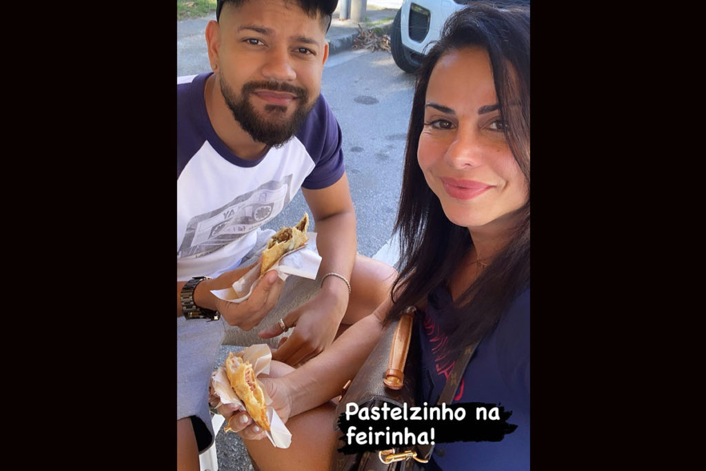 Viviane Araujo e Guilherme Militão comendo pastel de feira