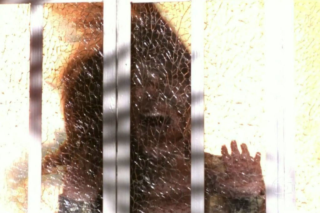 Carmen vê o vidro da porta se quebrar