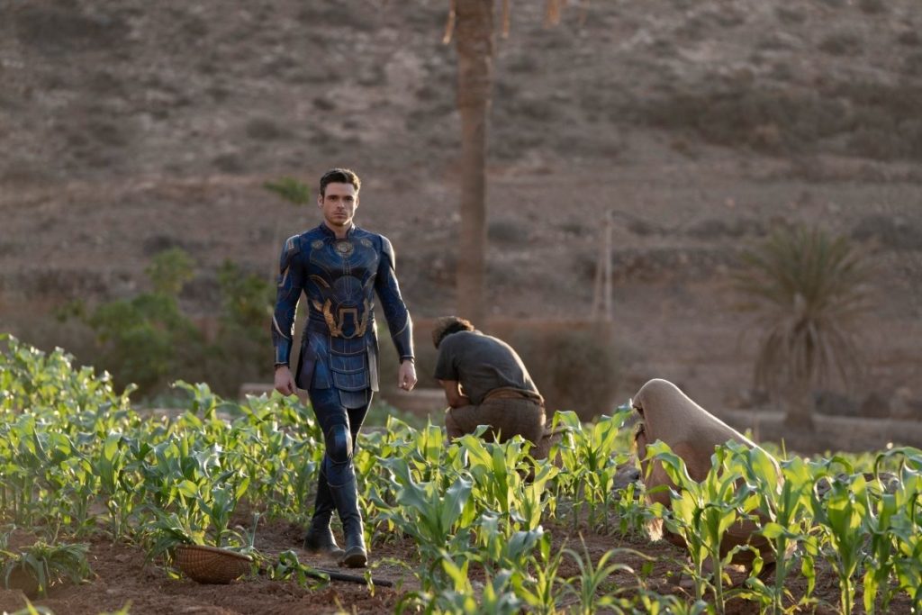 ikaris (richard madden) caminhando em plantação em cena de eternos