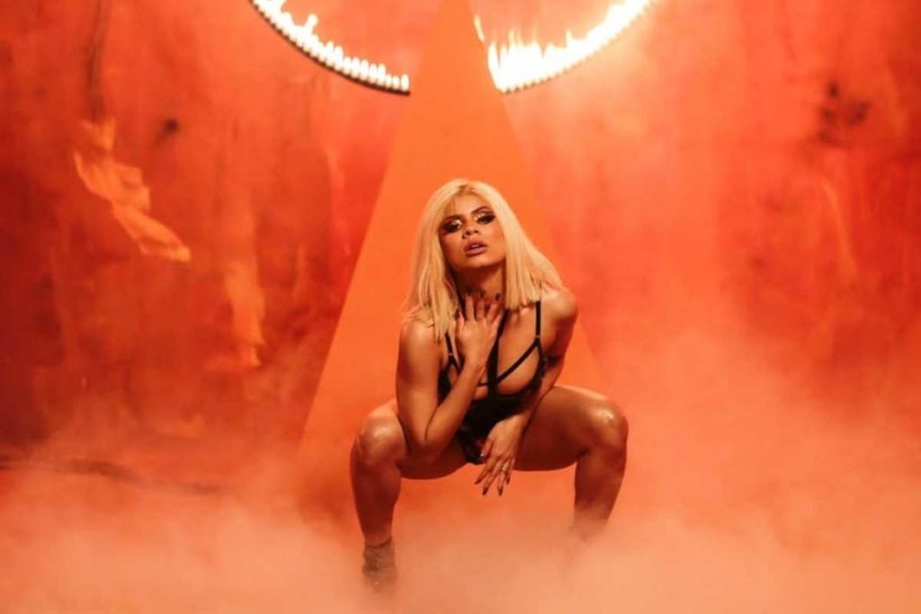 lexa agachada com body preto em cena do clipe de bruta