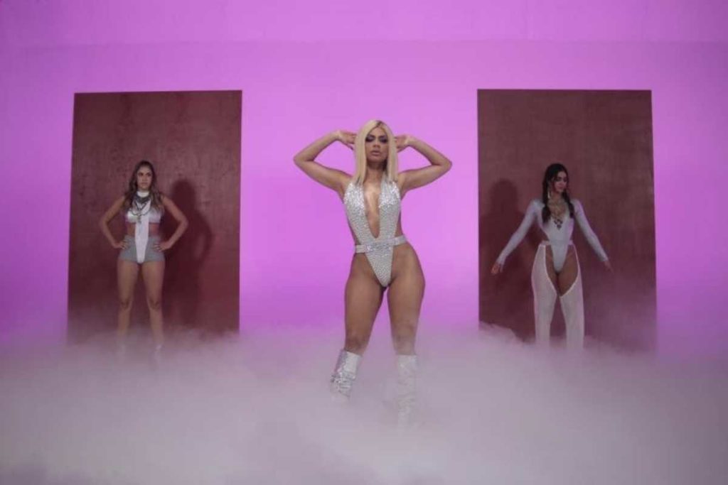 lexa com as dançarinas dançando com look prata em cena do clipe de bruta