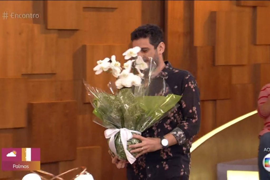 André Curvello entrega vaso de flor para Fátima Bernardes
