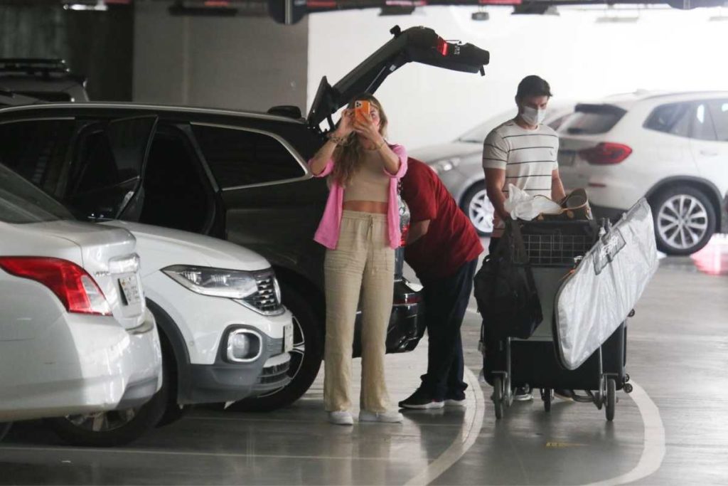 grazi massafera e namorado alexandre machafer esperando funcionário colocar bagagens no port-amalas de carro