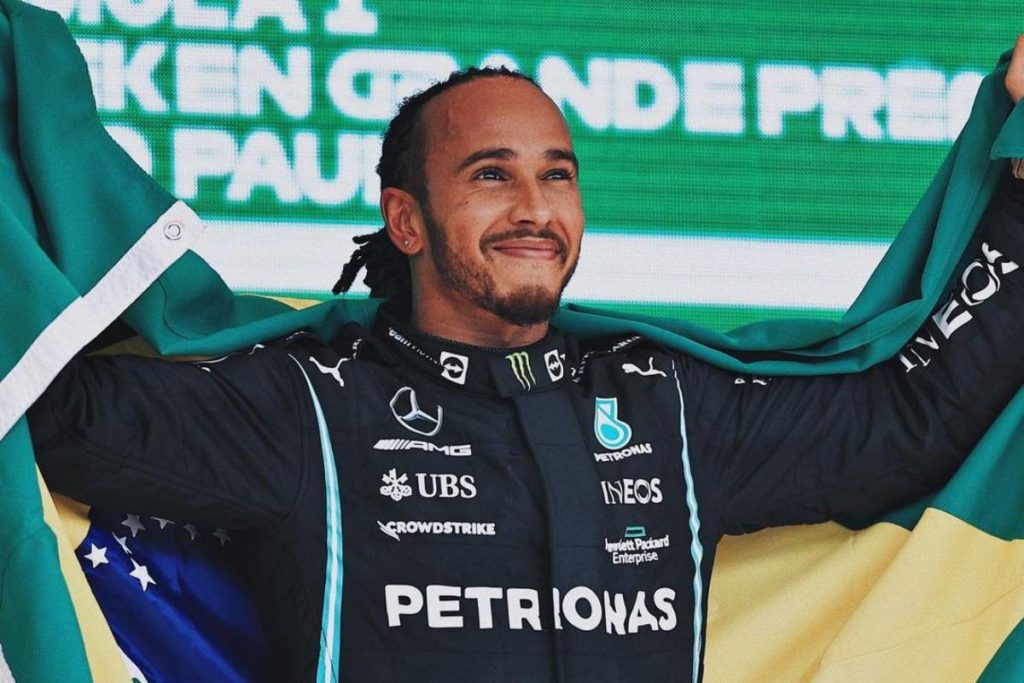 lewis hamilton posando com bandeira do brasil nas costas após vencer o gp de são paulo da fórmula 1