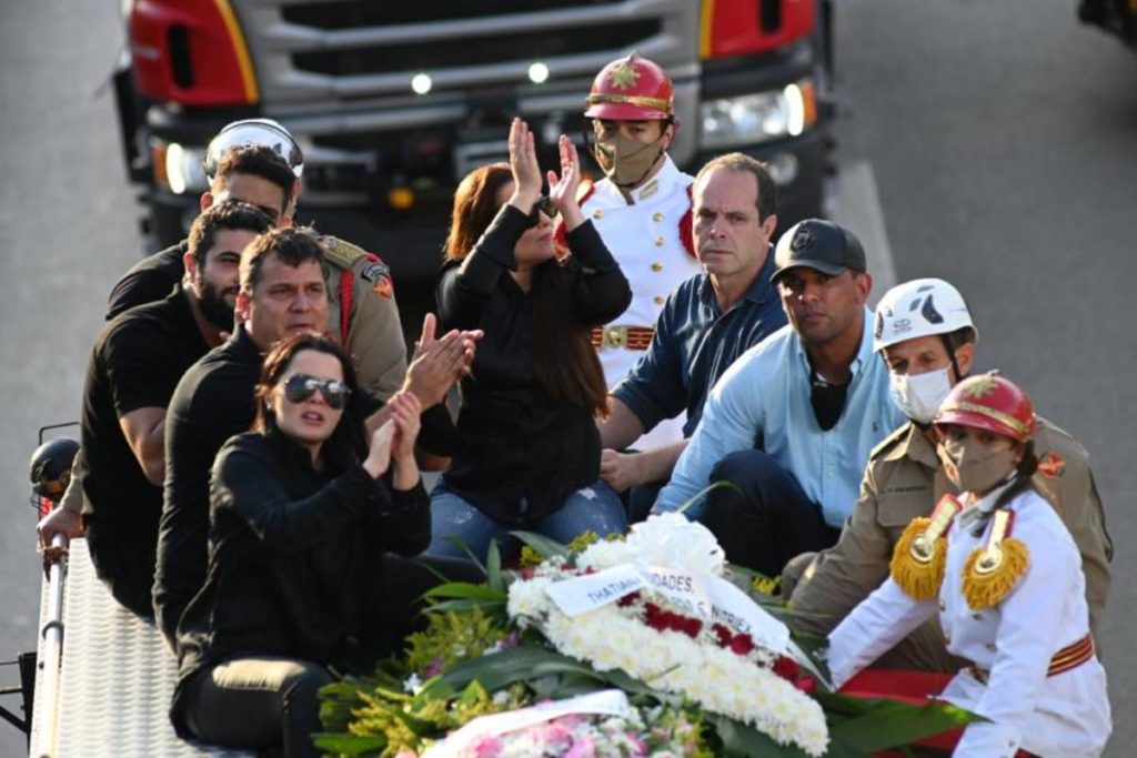 Maiara, Maraísa, Henrique e Juliano acompanhando corpo de Marília Mendonça em cortejo no carro dos bombeiros