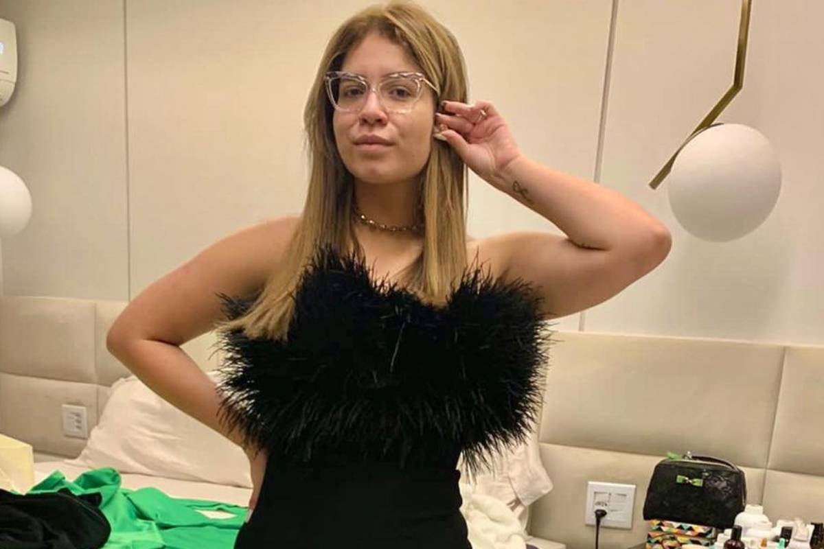 marilia mendonça posando estilosa com look preto e óculos transparentes