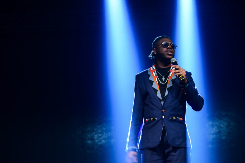 Yuri Marçal cantando em palco de premiação.