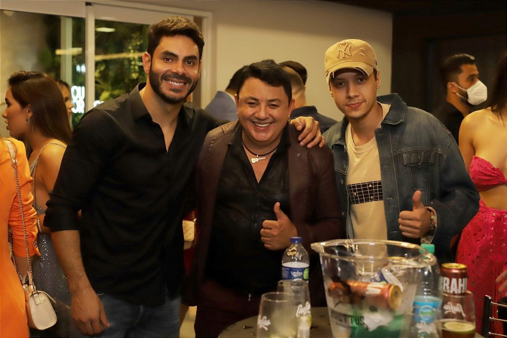 Rodolffo posando para foto com amigos.