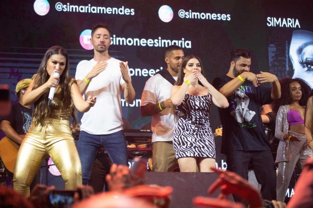 famosos fazendo dancinha no palco durnate show de simone e simaria