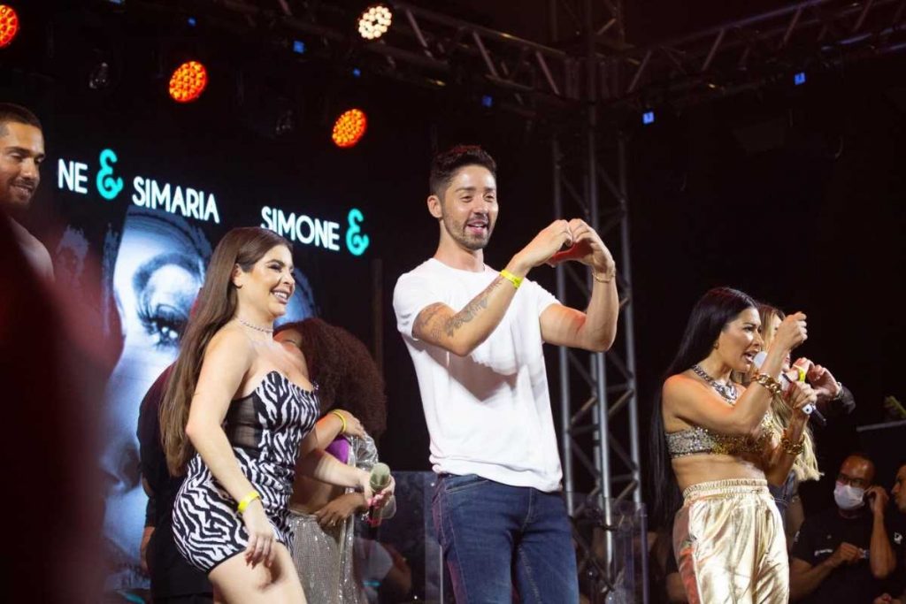 rico melquiades fazendo coração para fãs no palco de show de simone e simaria