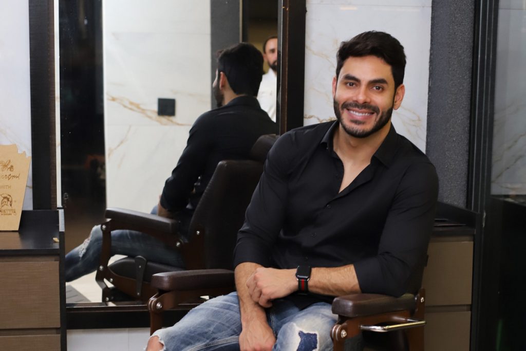 Rodolffo posando para foto em barbearia.