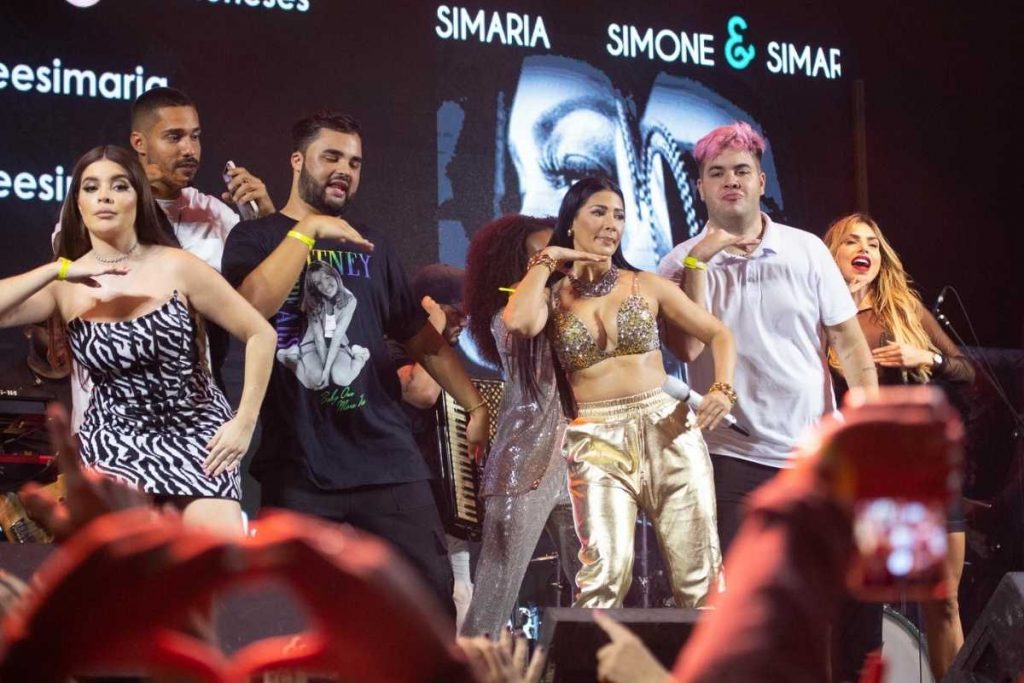 famosos fazendo dancinha no palco durnate show de simone e simaria