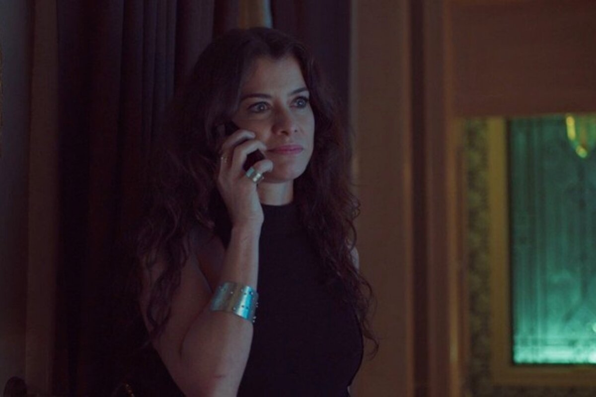 Alinne Moraes em cena de Um Lugar ao Sol, ao telefone, de vestido preto