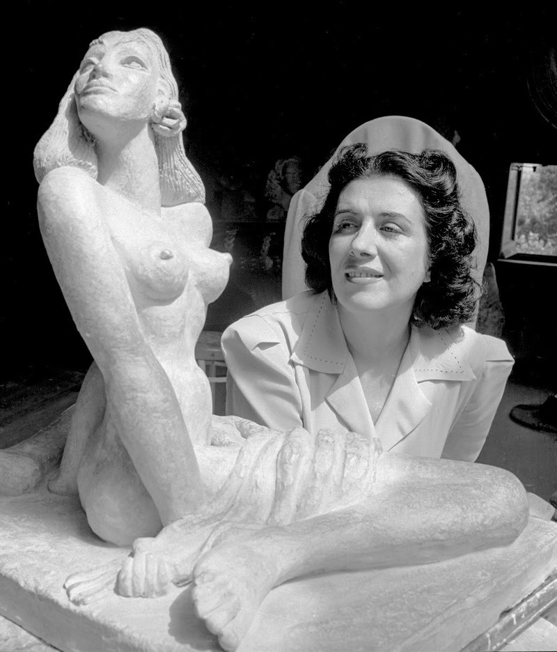 Maria Martins ao lado de escultura.