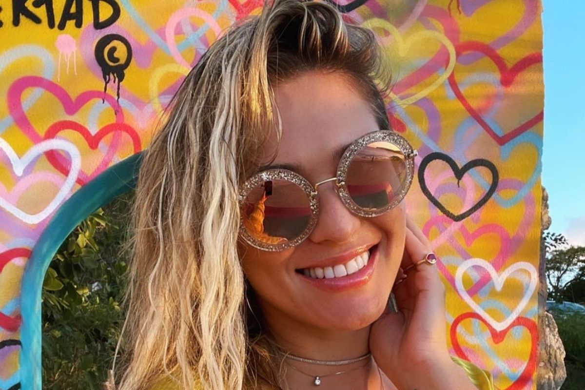 Lívia Andrade em selfie sorrindo, usando óculos de sol