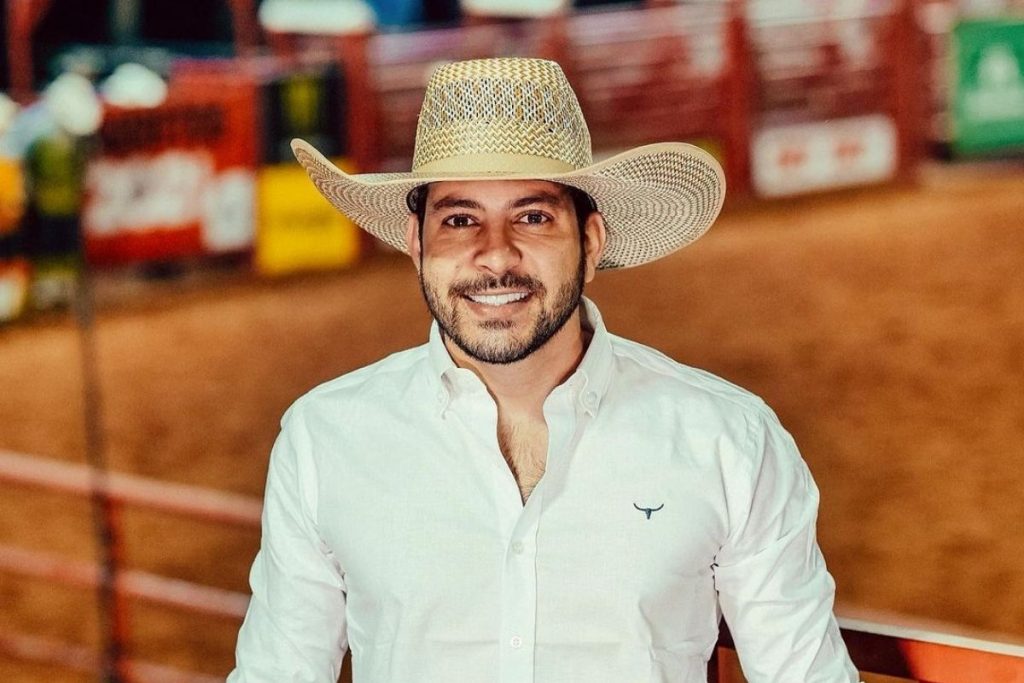 Caio Afiune sorrindo em foto, usando chapéu de fazendeiro