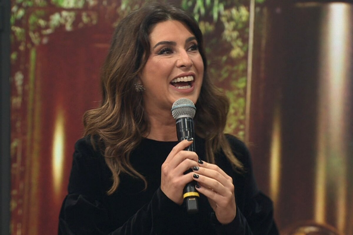 Fernanda Paes Leme sorrindo, segurando o microfone