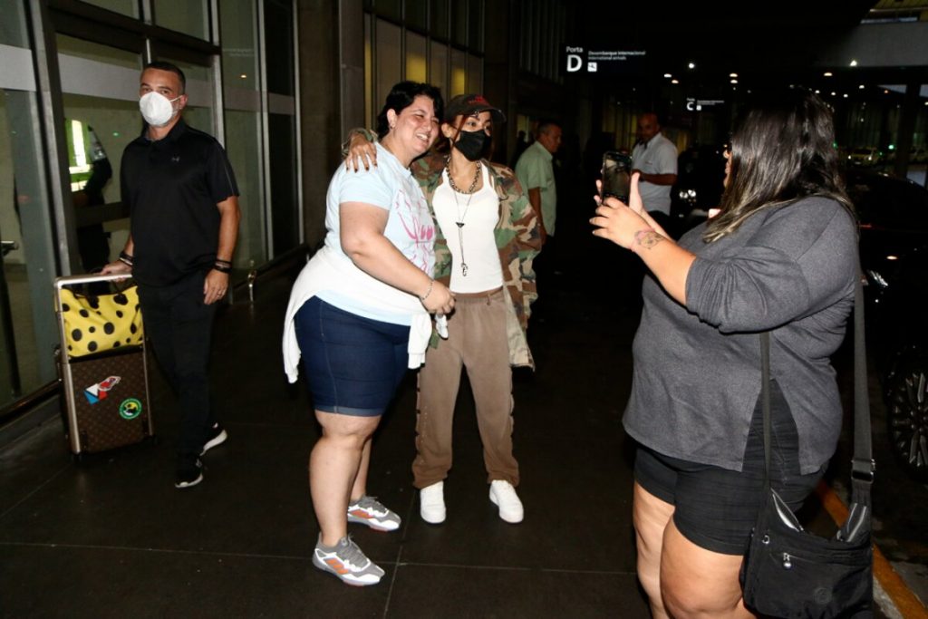 Anitta posa com fã no aeroporto