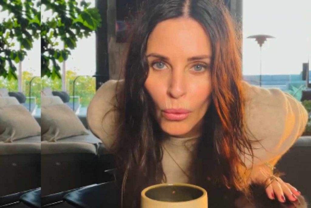 Courteney Cox assoprando vela