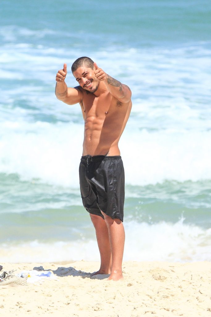 Douglas Sampaio posando para foto em praia do RJ