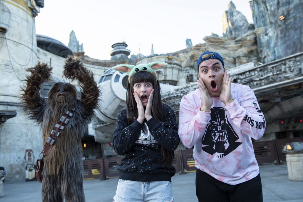 Luccas Neto e Gi Alparone posando para foto em parque da Disney