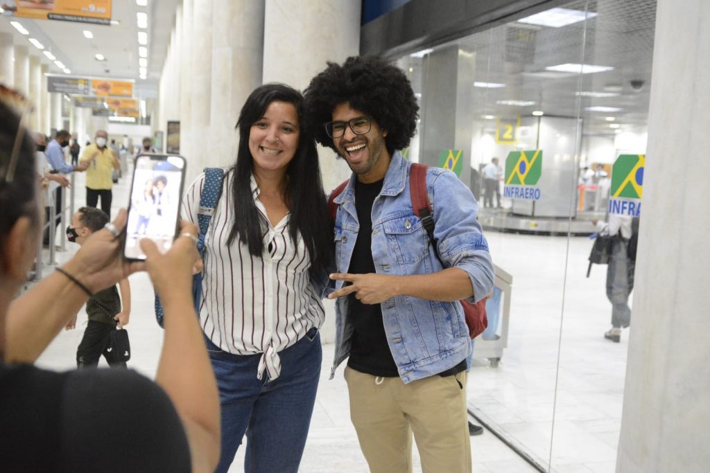 Luciano posando para fotos com fãs em aeroporto