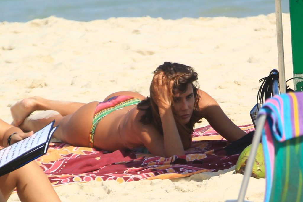 Deborah Secco na praia, mexendo no celular