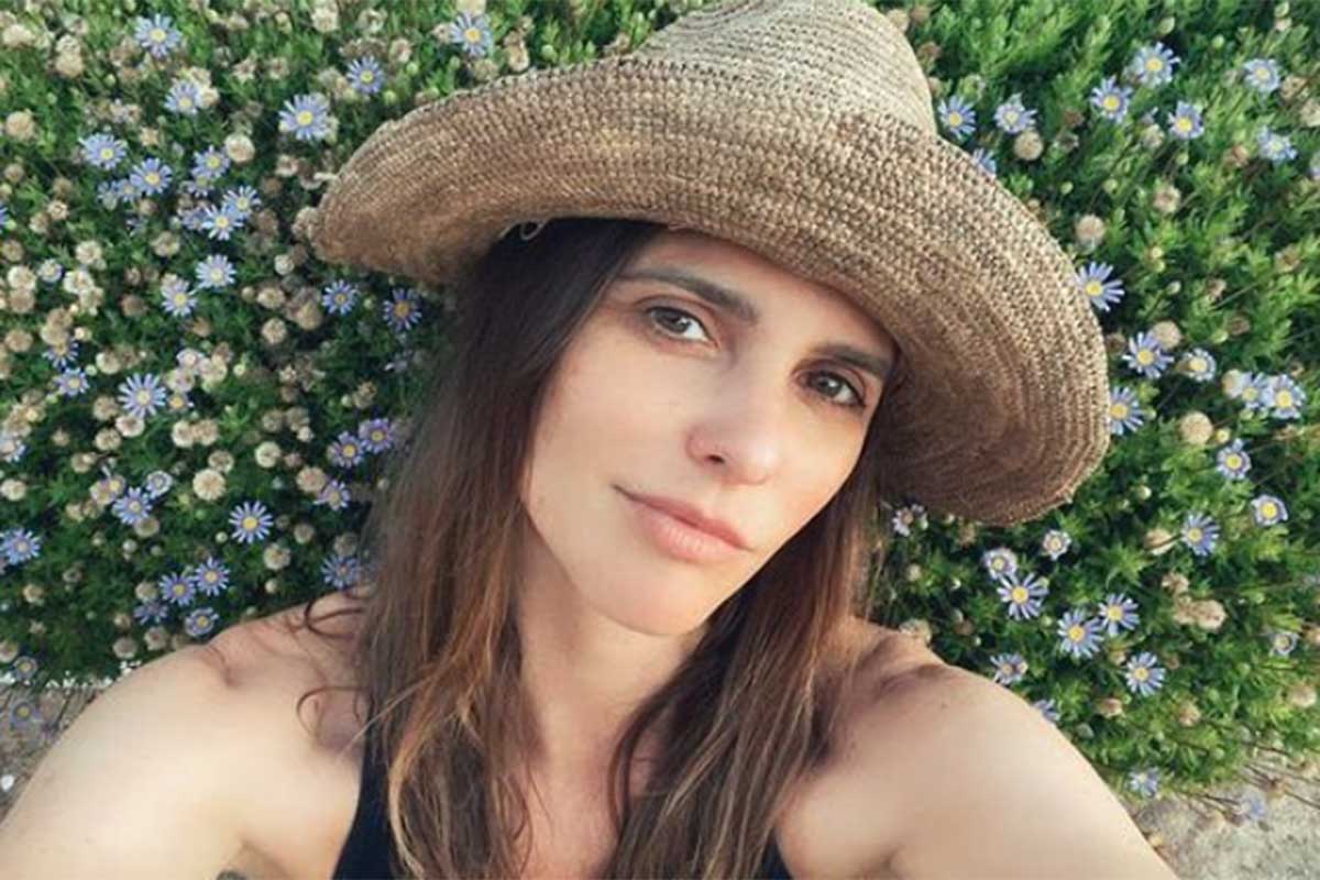 Fernanda Lima de chapéu, no jardim