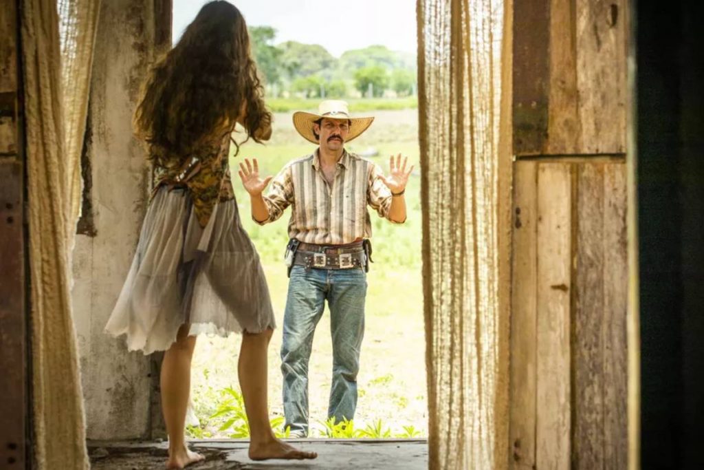 juma (alanis guillen) ameaçando tibério (guido) com arma em sua tapera em pantanal