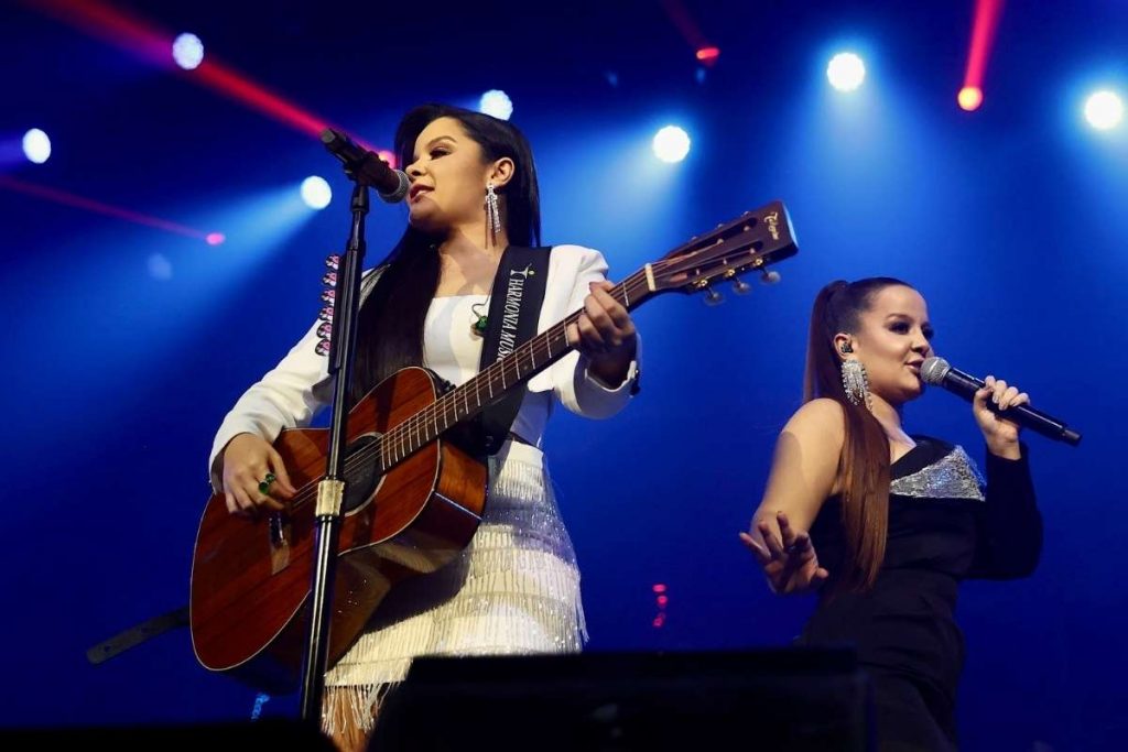 Maraísa toca violão em show com Maiara. 