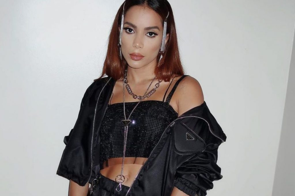 Cantora Anitta posando com roupa preta e acessórios pratas