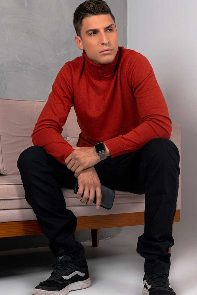 Felipe Prior de blusa vermelha, olhando para o lado